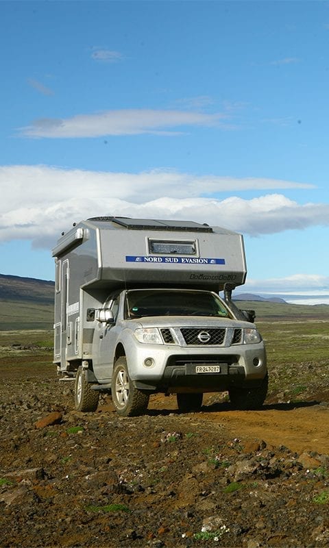 4x4 Camper sur une piste ocre dans un paysage volcanique pendant le raid campers tour Askja en Islande, juillet 2020